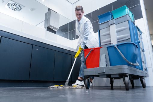 A woman diligently cleans a kitchen using a mop, ensuring a spotless and hygienic environment.